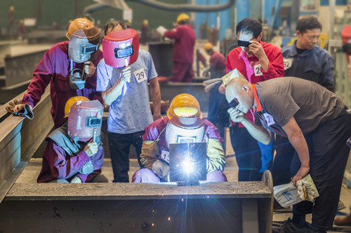 在比赛现场，选手们精湛焊接技术，引来一旁观摩的工人们的好评。记者 任前蔚 摄RQW_7411_1_副本.jpg